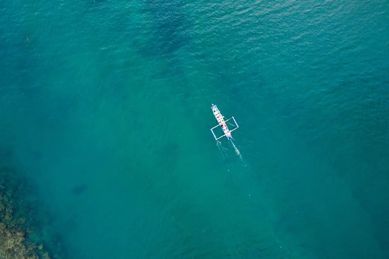 A small white boat surrounded by turquoise sea
